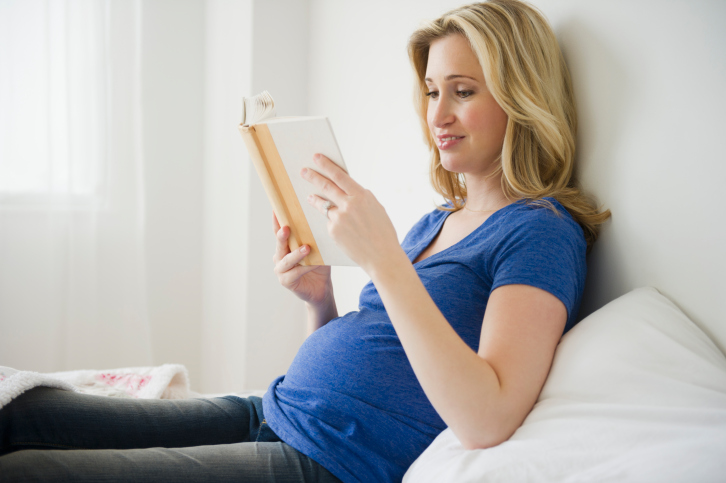 mother reading book in early pregnancy